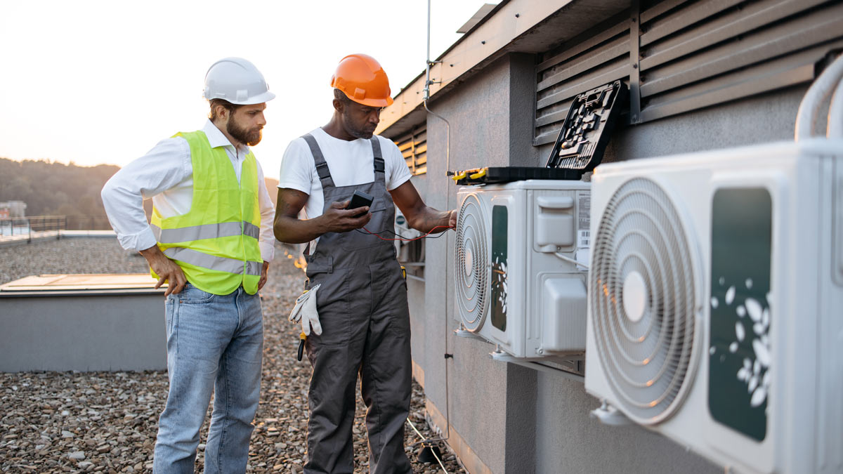 HVAC-repairmen-with-multimeter-fixing-air-conditioner